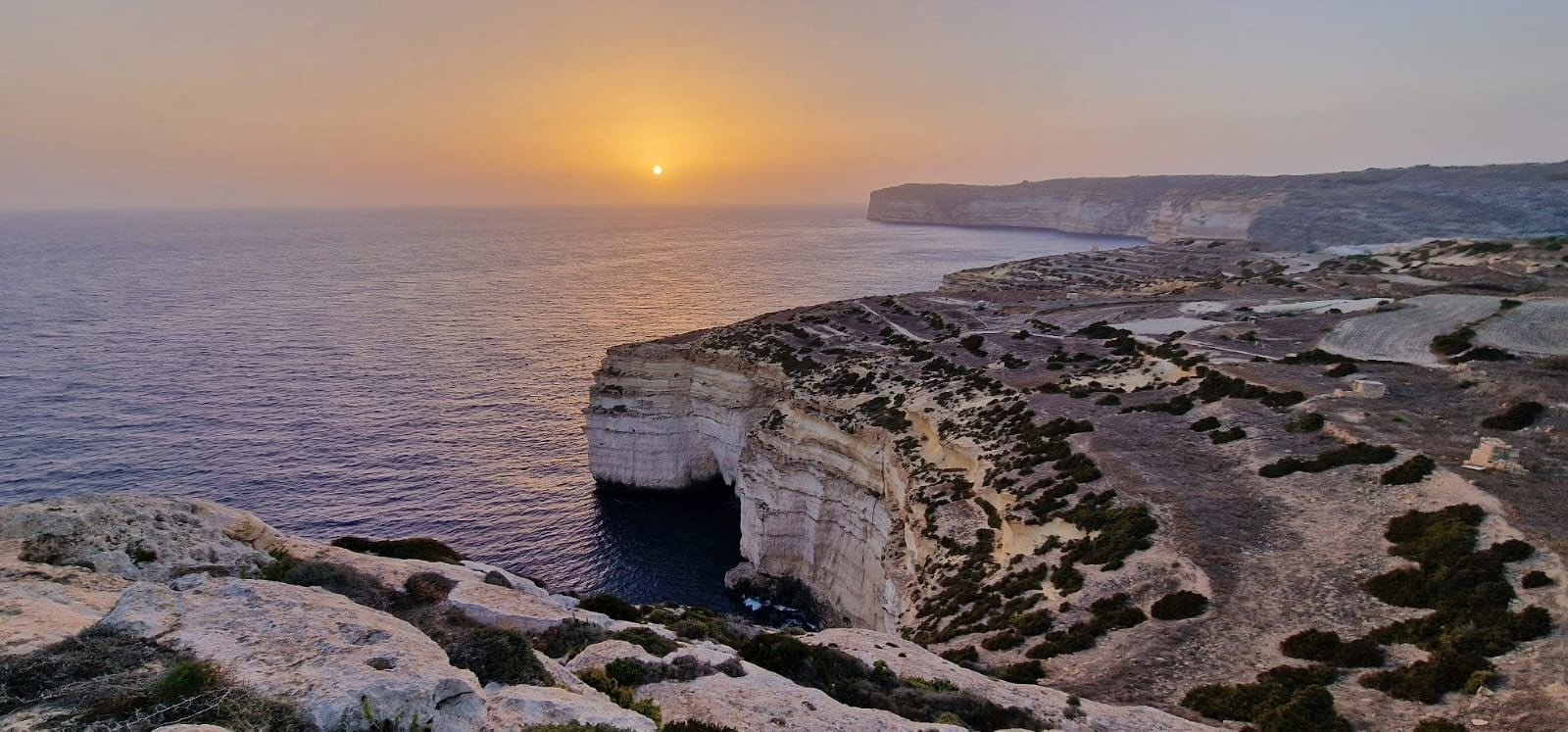 Sunset over Gozo cliffs and the Mediterranean sea