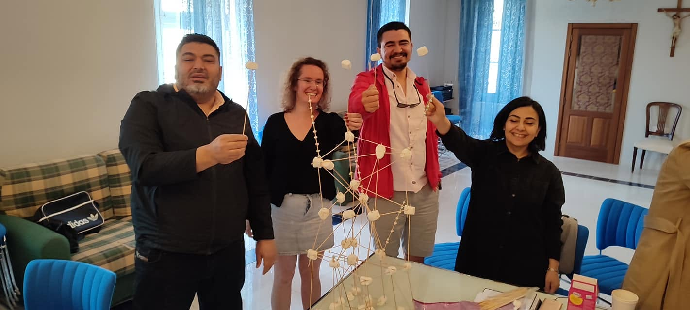 Participants building a marshmallow and spaghetti tower during a teambuilding activity